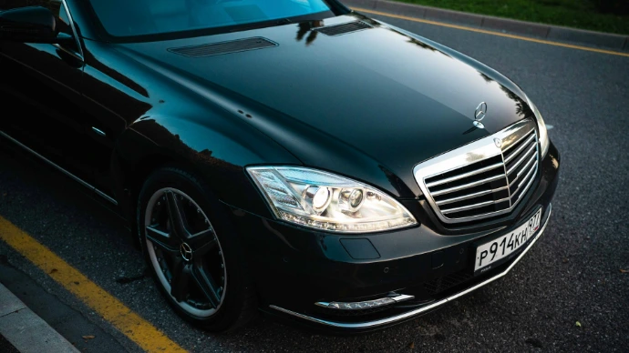 A shiny black mercedes-benz car on the road